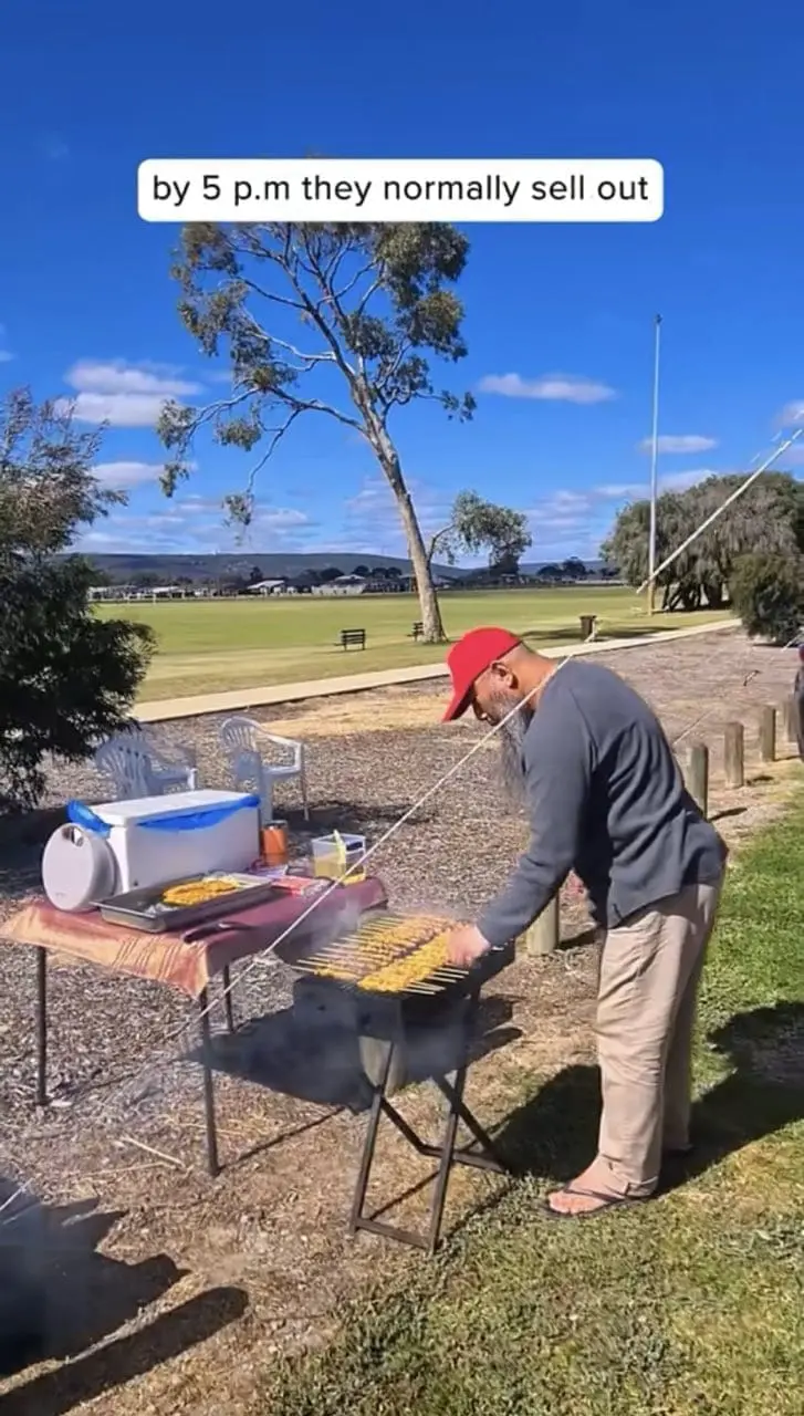 Malaysian man grilling satay in Australia