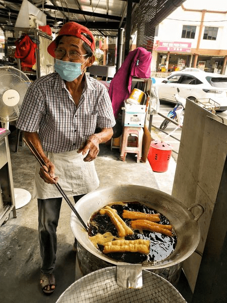 "I only earn RM5 a day" 75yo uncle braves FMCO storm by selling "youtiao" at RM1 each