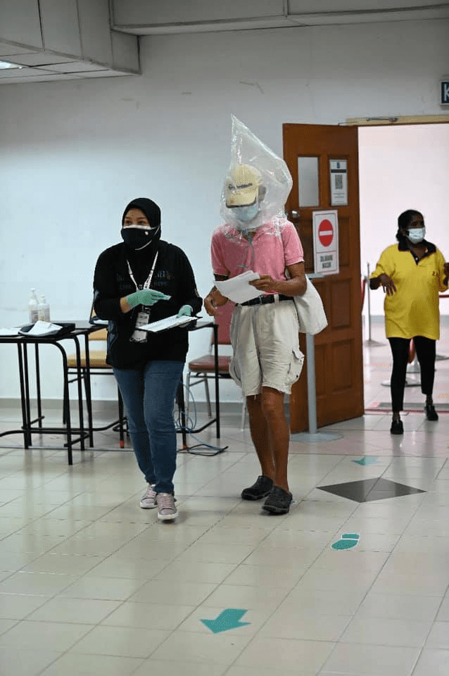 Uncle with absurd face shield generously treats frontliners to lunch after his jab