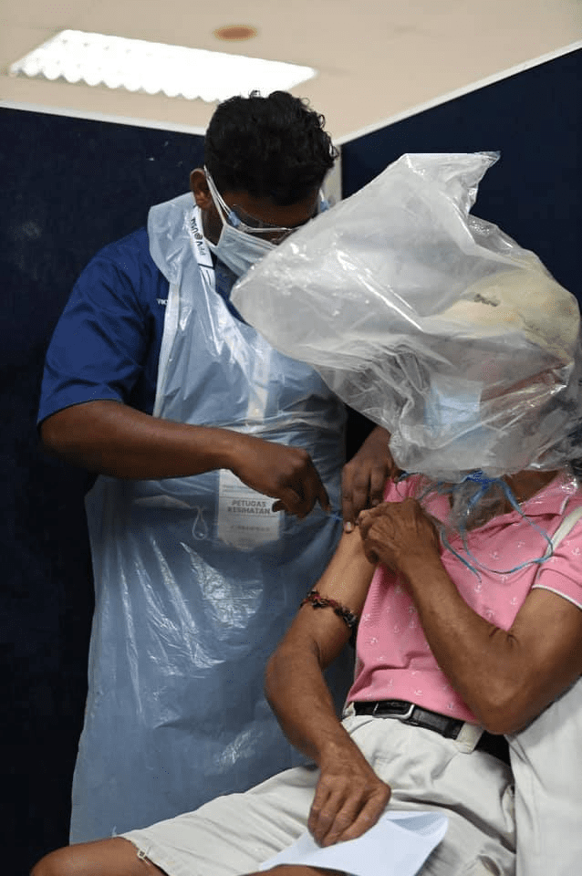 Uncle with absurd face shield generously treats frontliners to lunch after his jab