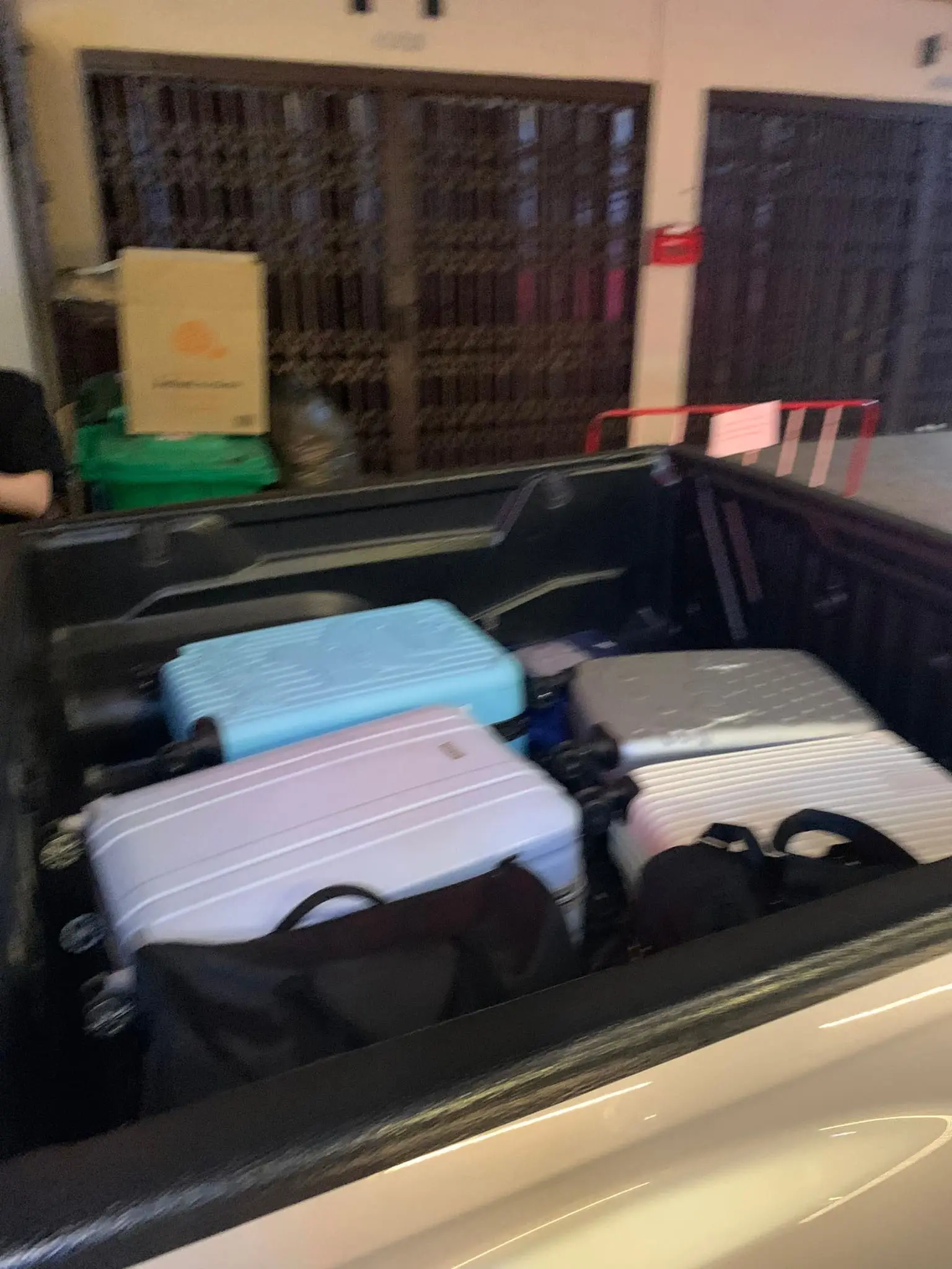 Four luggage placed behind a car