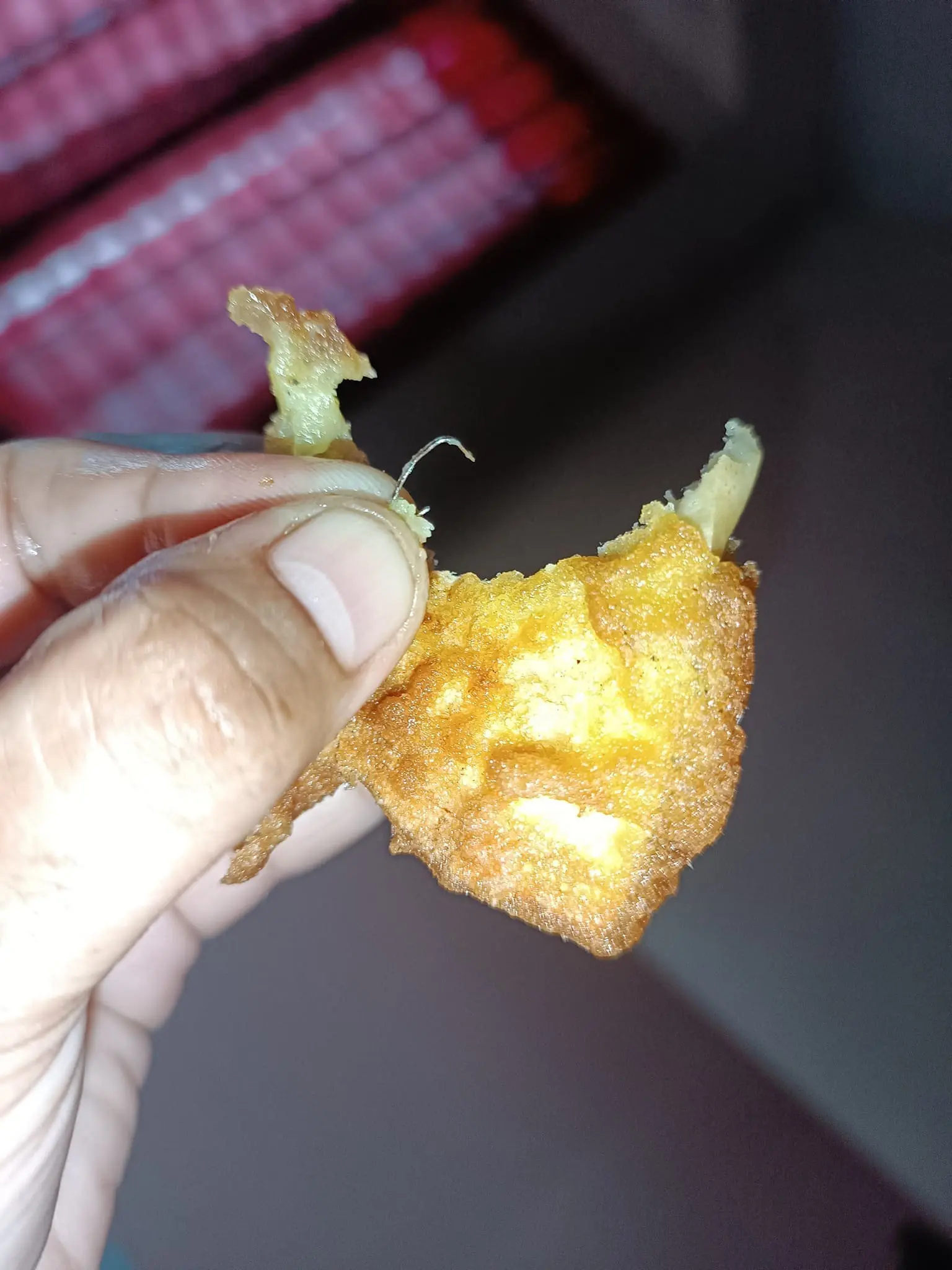 A msian woman showing a staple pin that she found inside the jackfruit fritters she bought from a stall. 