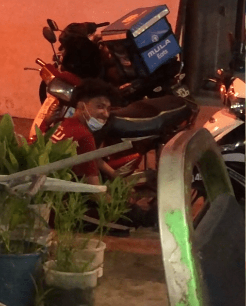 A man who was partially vaxxed sitting outside a food stall. 