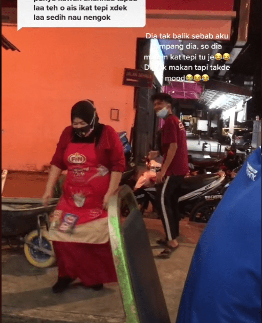 Food stall staff handing over his takeaway food.