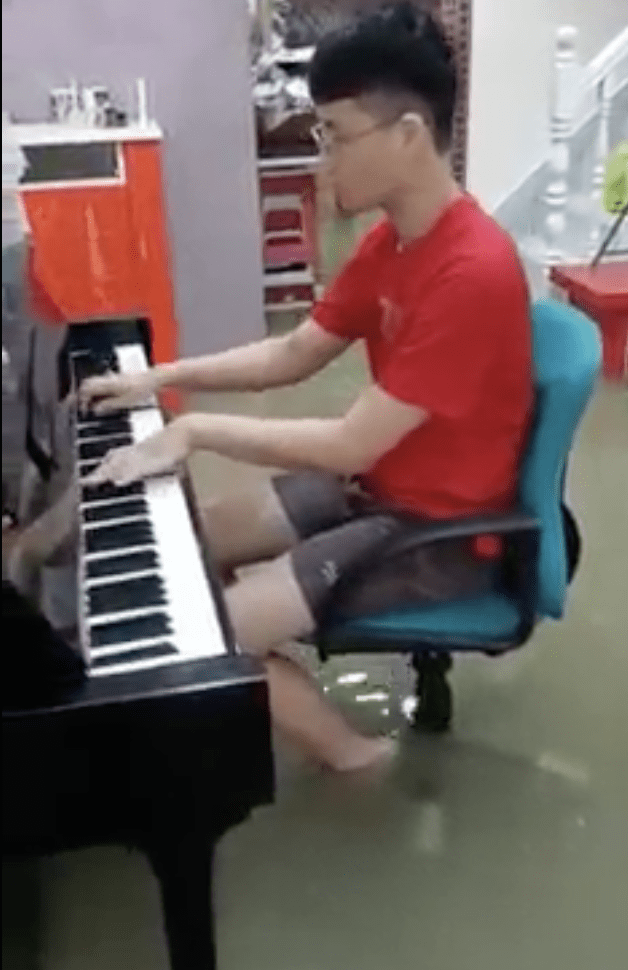 Mans play piano despite flooding in his house 04