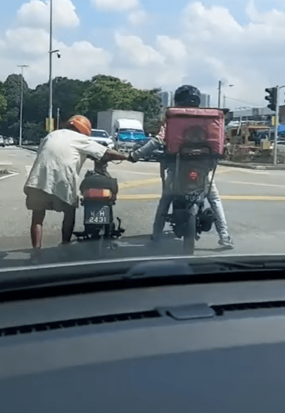 Kindhearted Foodpanda rider helps elderly man push his motorbike under the hot sun