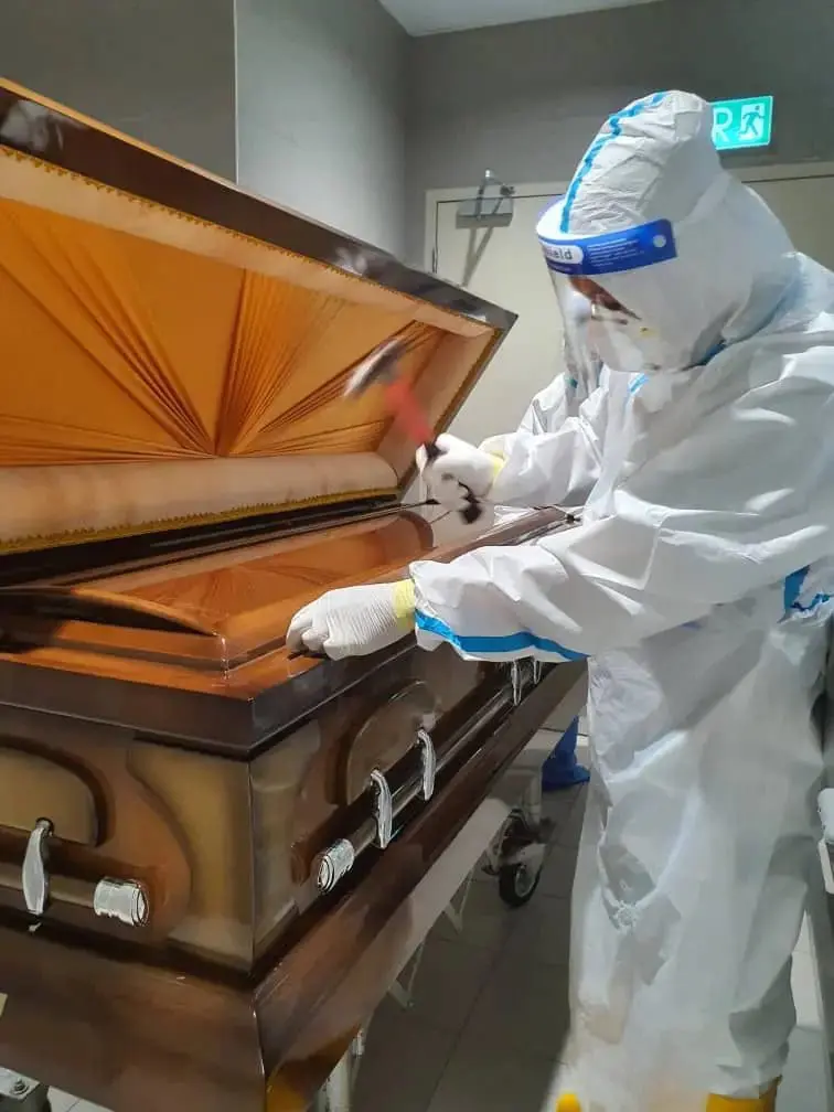 Terrence sealing the coffin of the COVID-19 patient. Image provided by Terrence for WeirdKaya 
