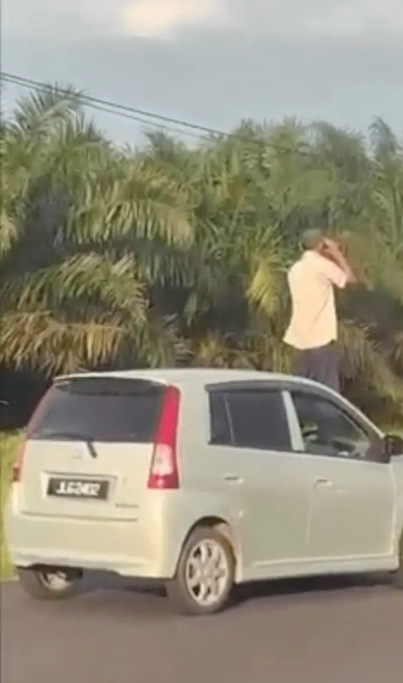 Uncle stuck in heavy Raya traffic climbs onto car bonnet and checks the road with binoculars 01-min