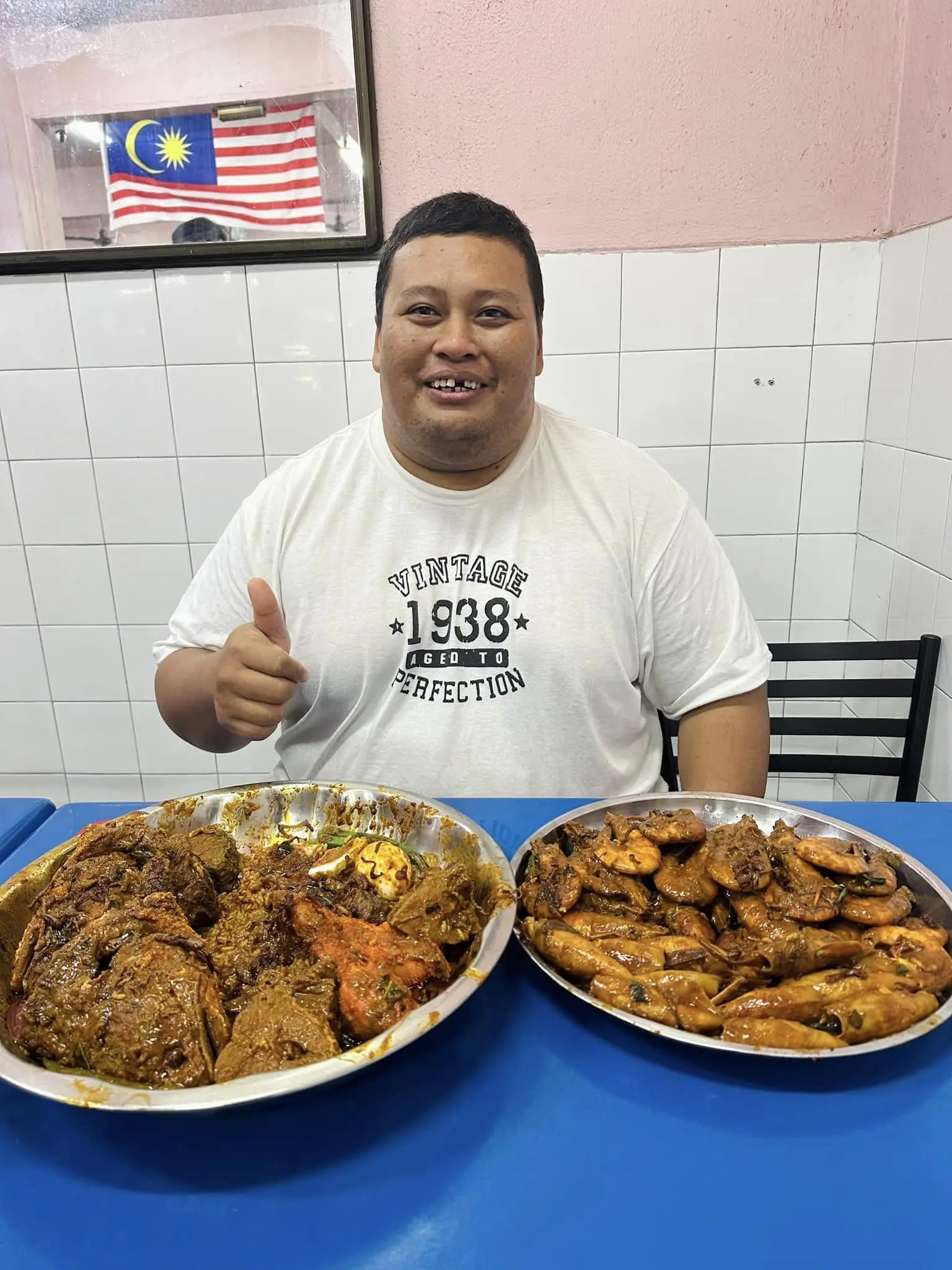 a man with nasi kandar on table at penang restaurant