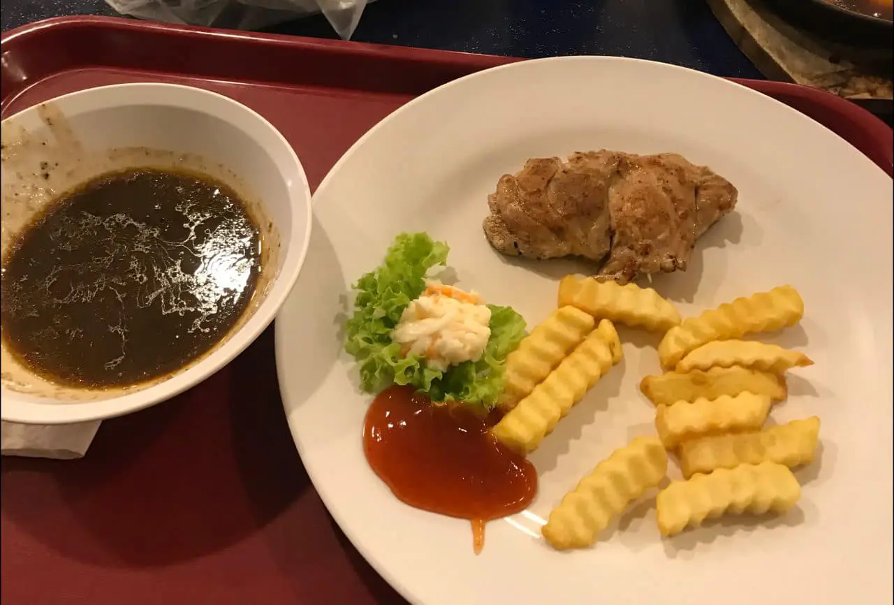 a plate of chicken chop of black pepper sauce