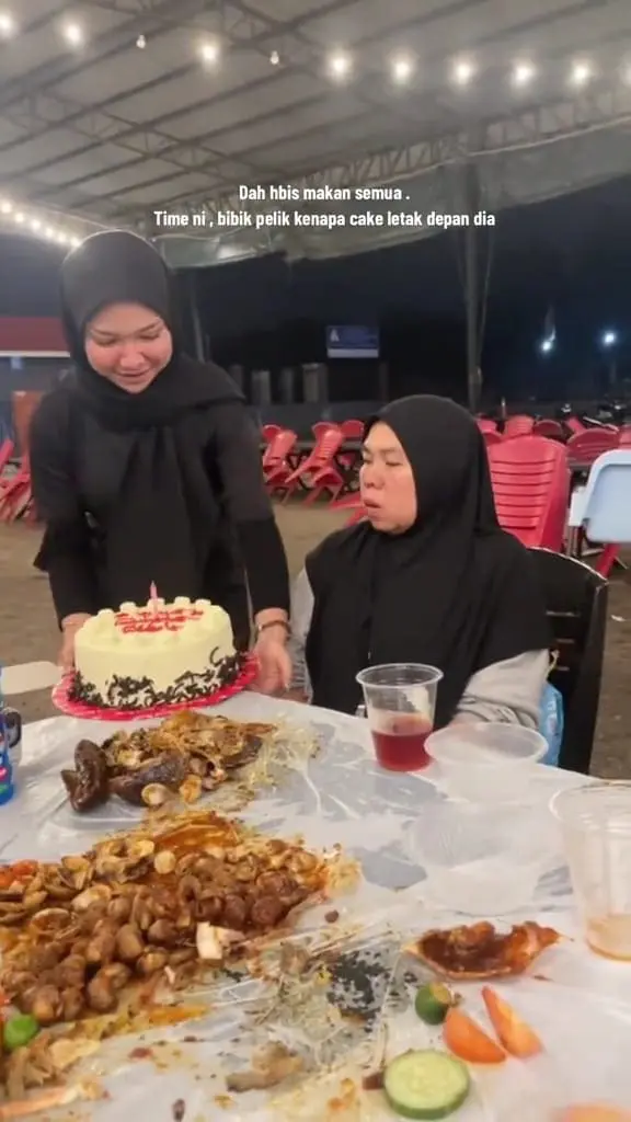 a woman presenting cake to a maid at a restaurant