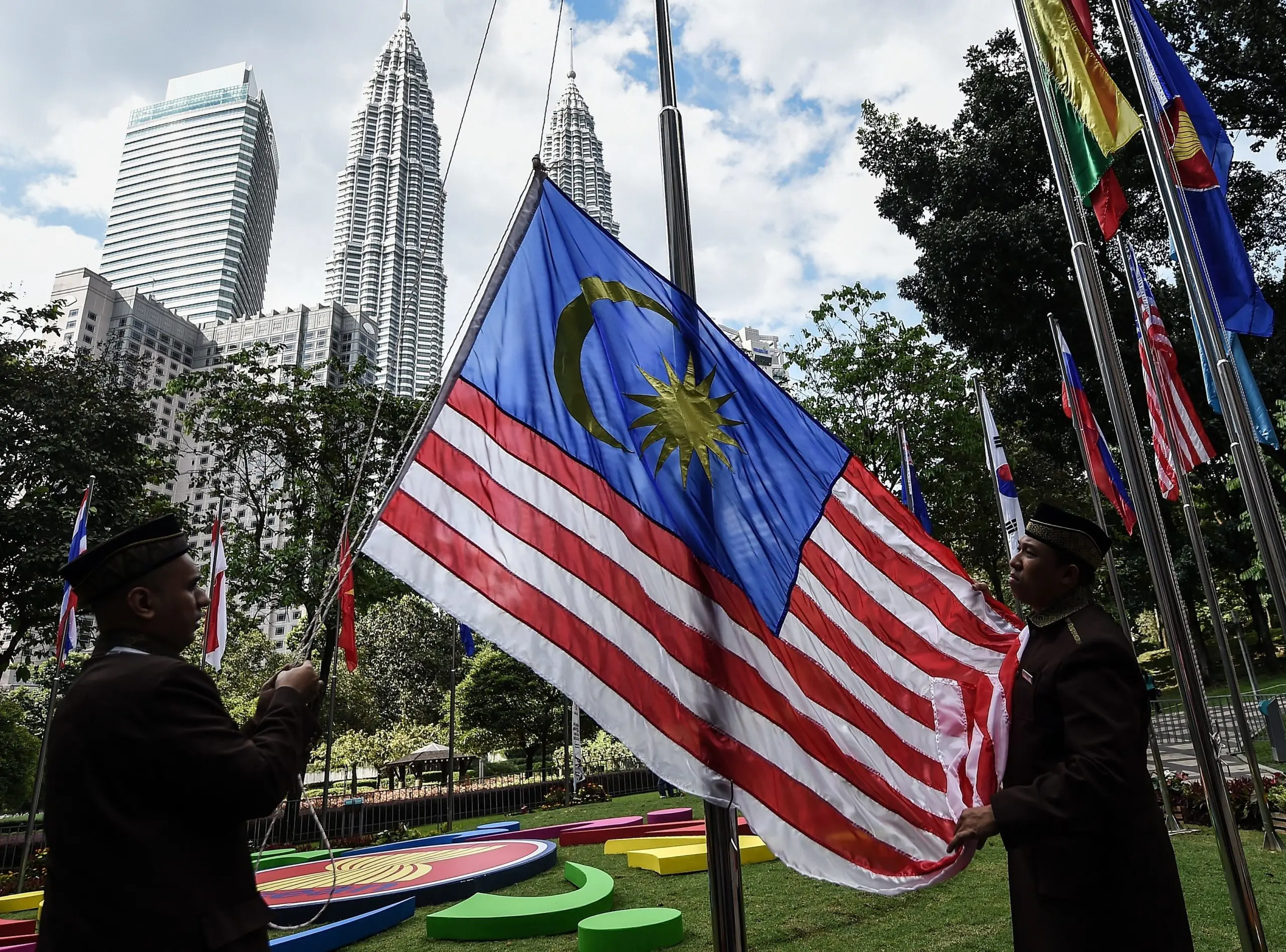 Officers hoisting the Jalur Gemilang