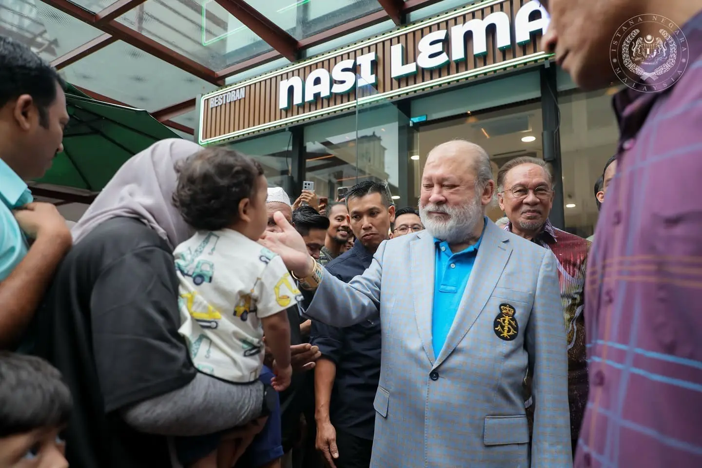 agong greeting a kid at nasi lemak restaurant in kl