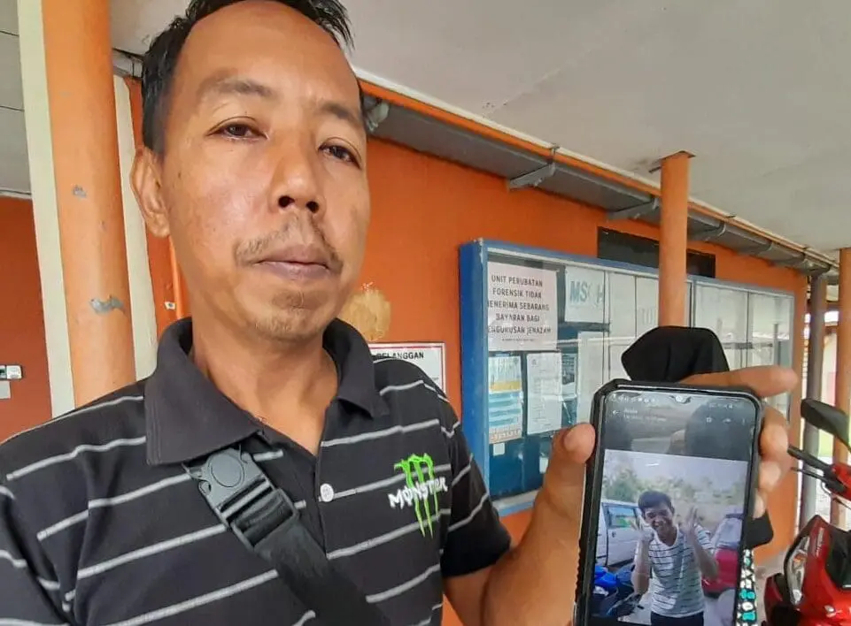 Aiman's stepfather shows his photo