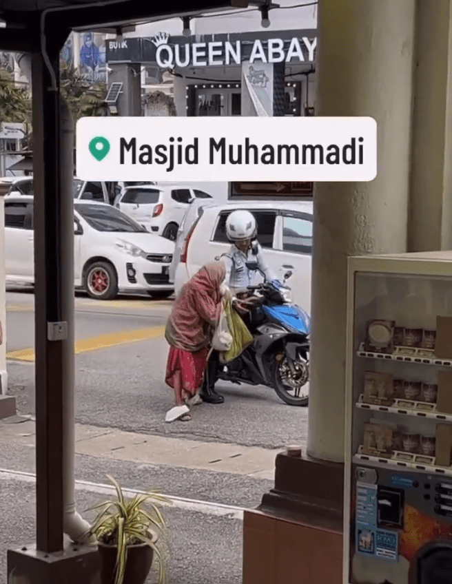 an elderly woman holding police officer's hand while getting down the motorbike