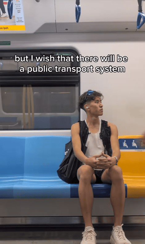 Andrew Kuan looking sideways while on the MRT