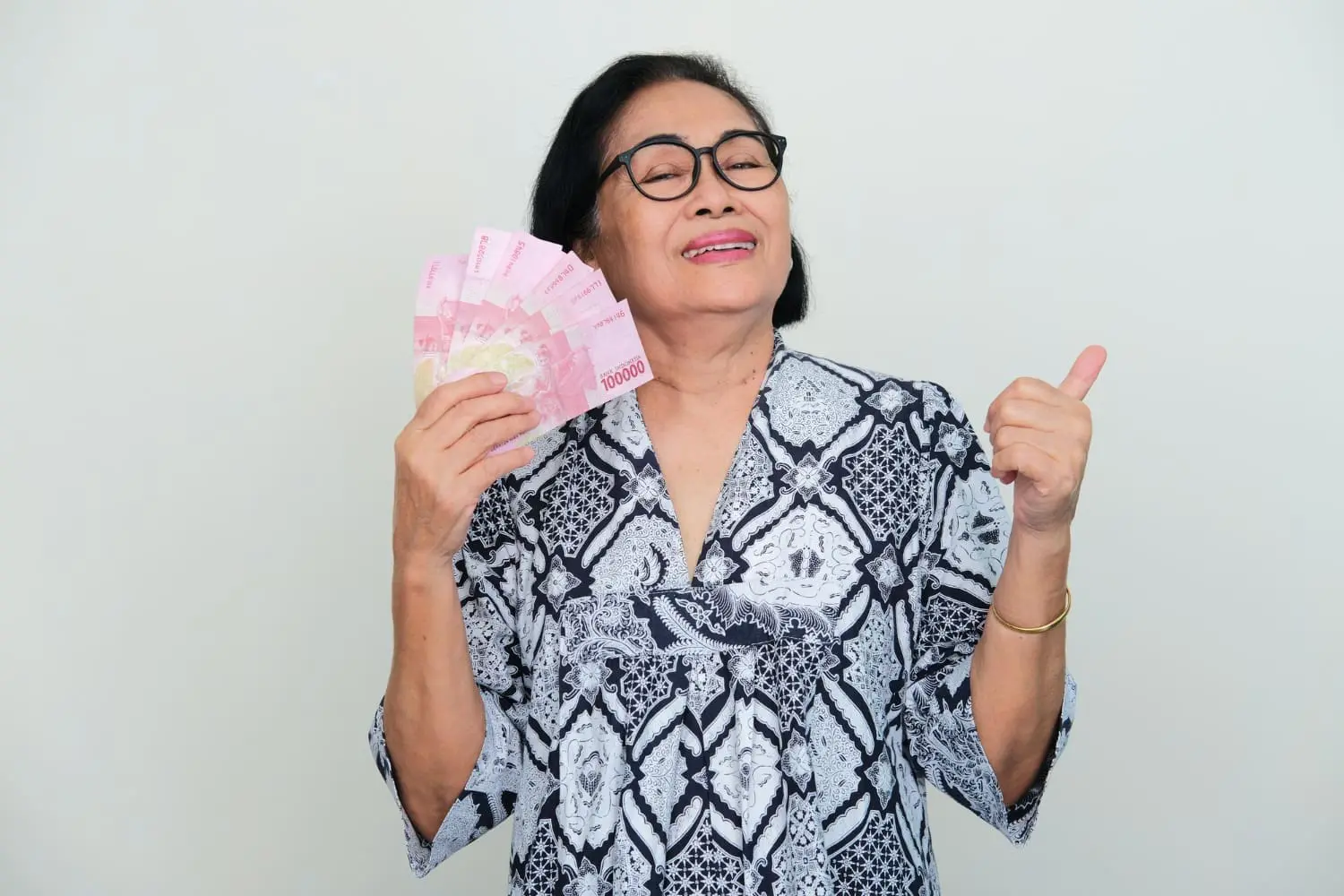 asian-elderly-women-showing-happy-expression-give-thumb-up-when-holding-money