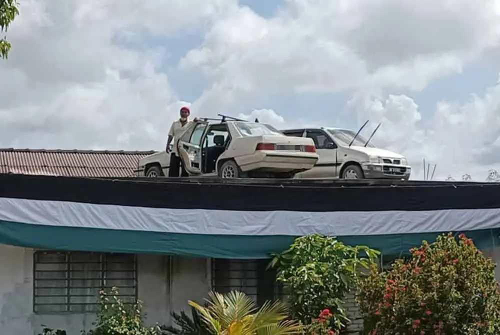 Awang Ali with the cars parked on house roof