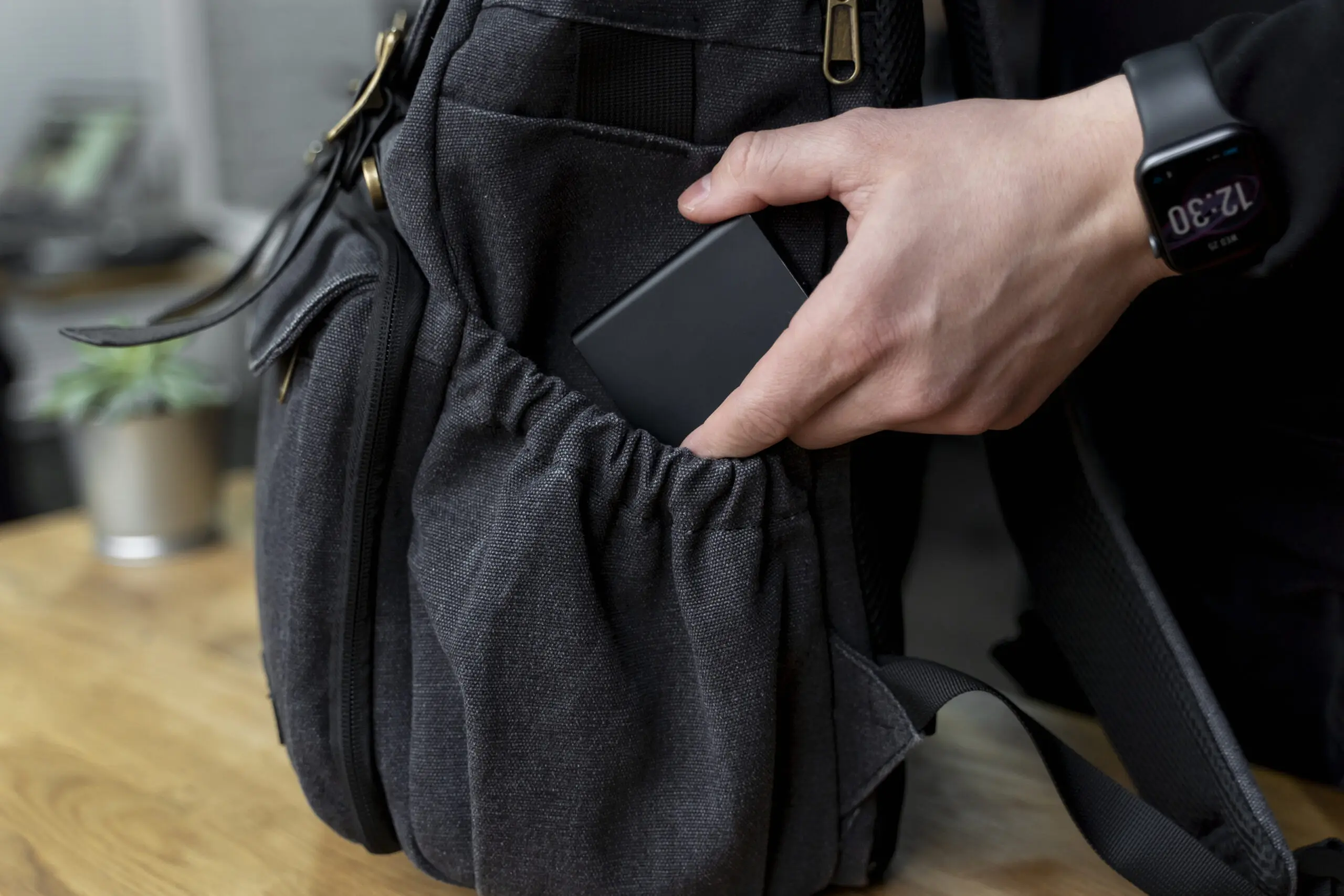 Man putting device into black haversack bag