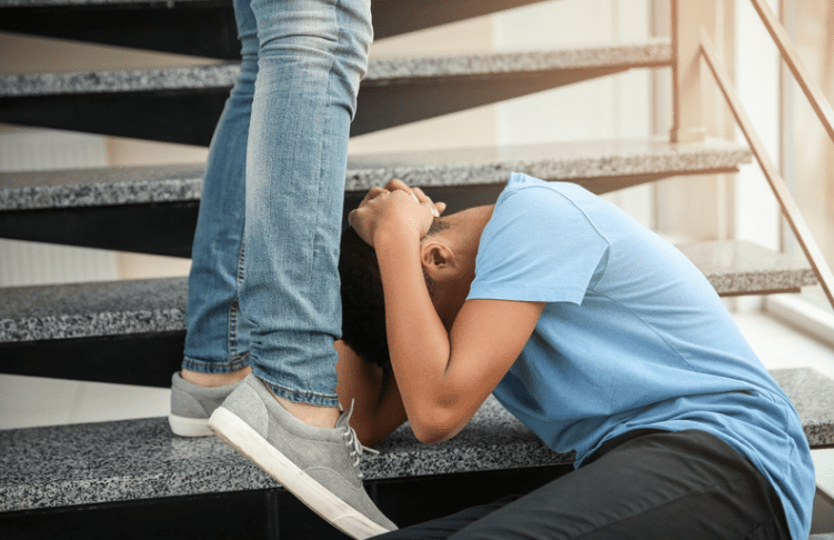 Boy covering his face while being attacked