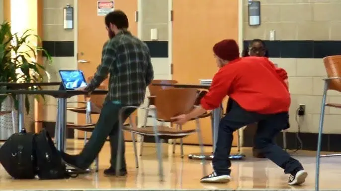 Boy doing the chair-pulling prank