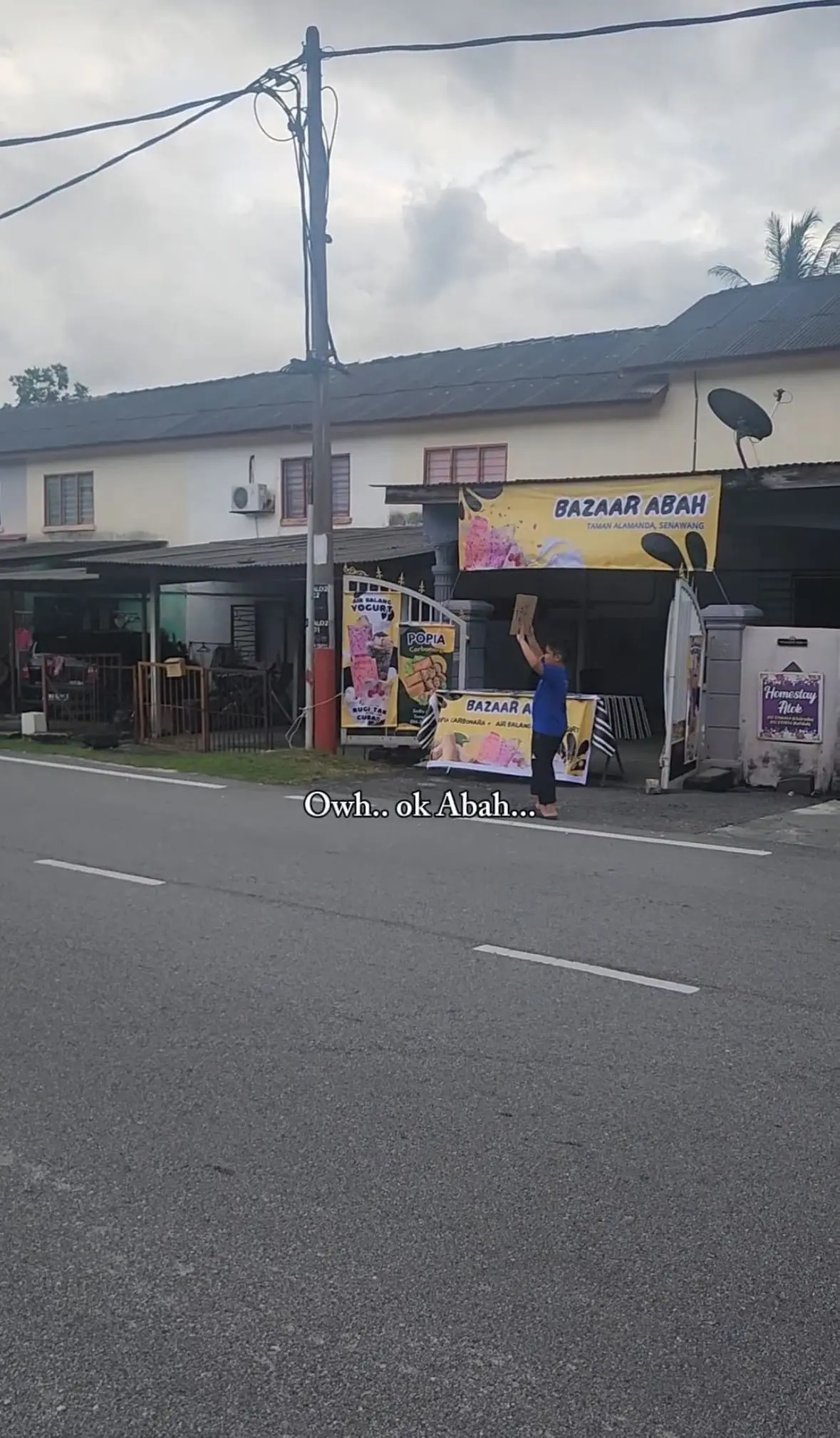 boy holding placard to promote his father's stall
