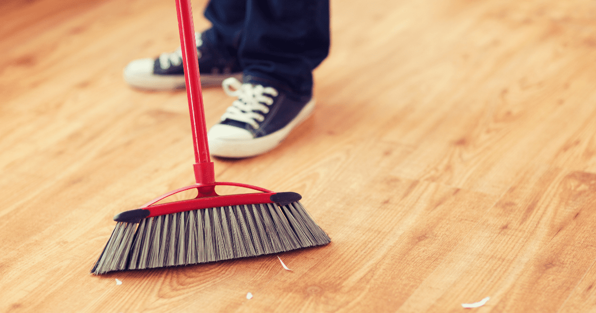 boy sweeping the floor