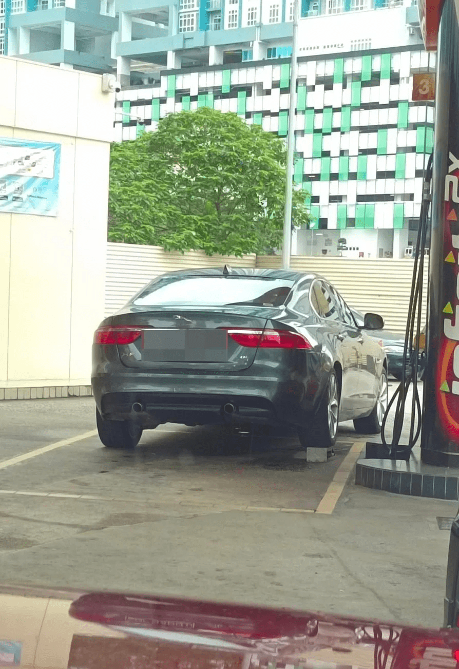 Jaguar with a brick underneath its right rear wheel