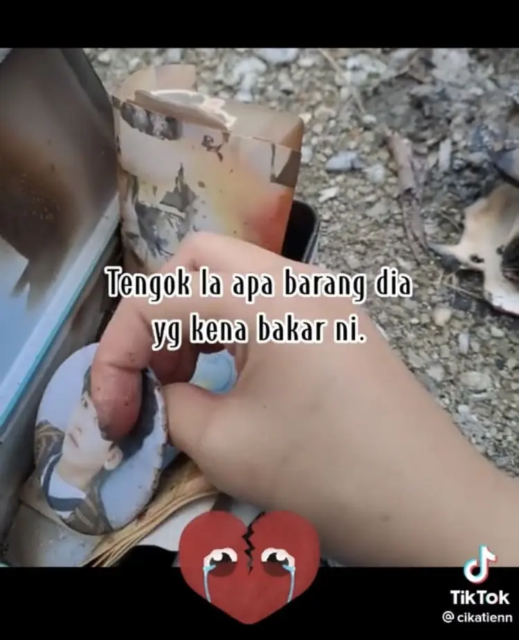 Girl searches through burnt K-Pop collectibles