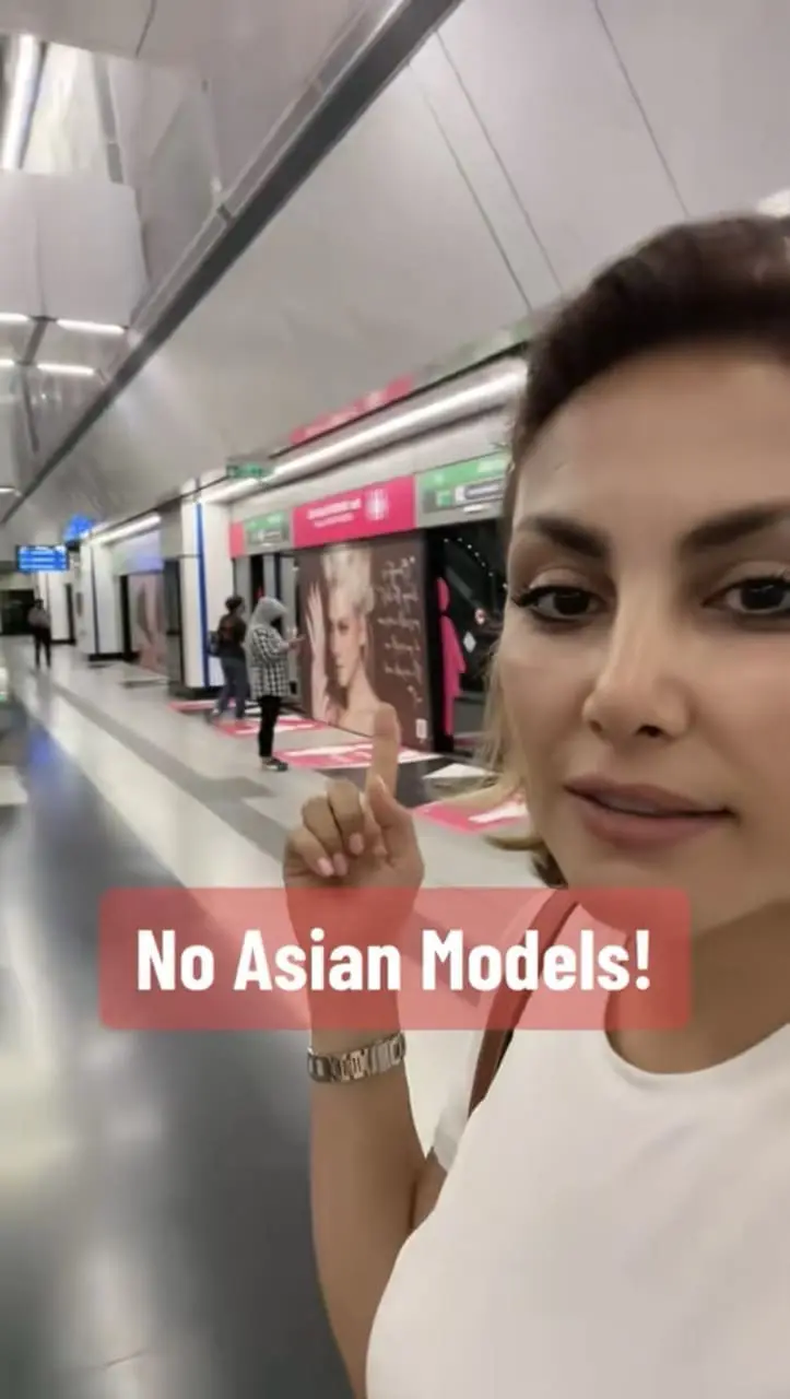 Foreign artist Sara Ryan pointing to ad which had a Western model