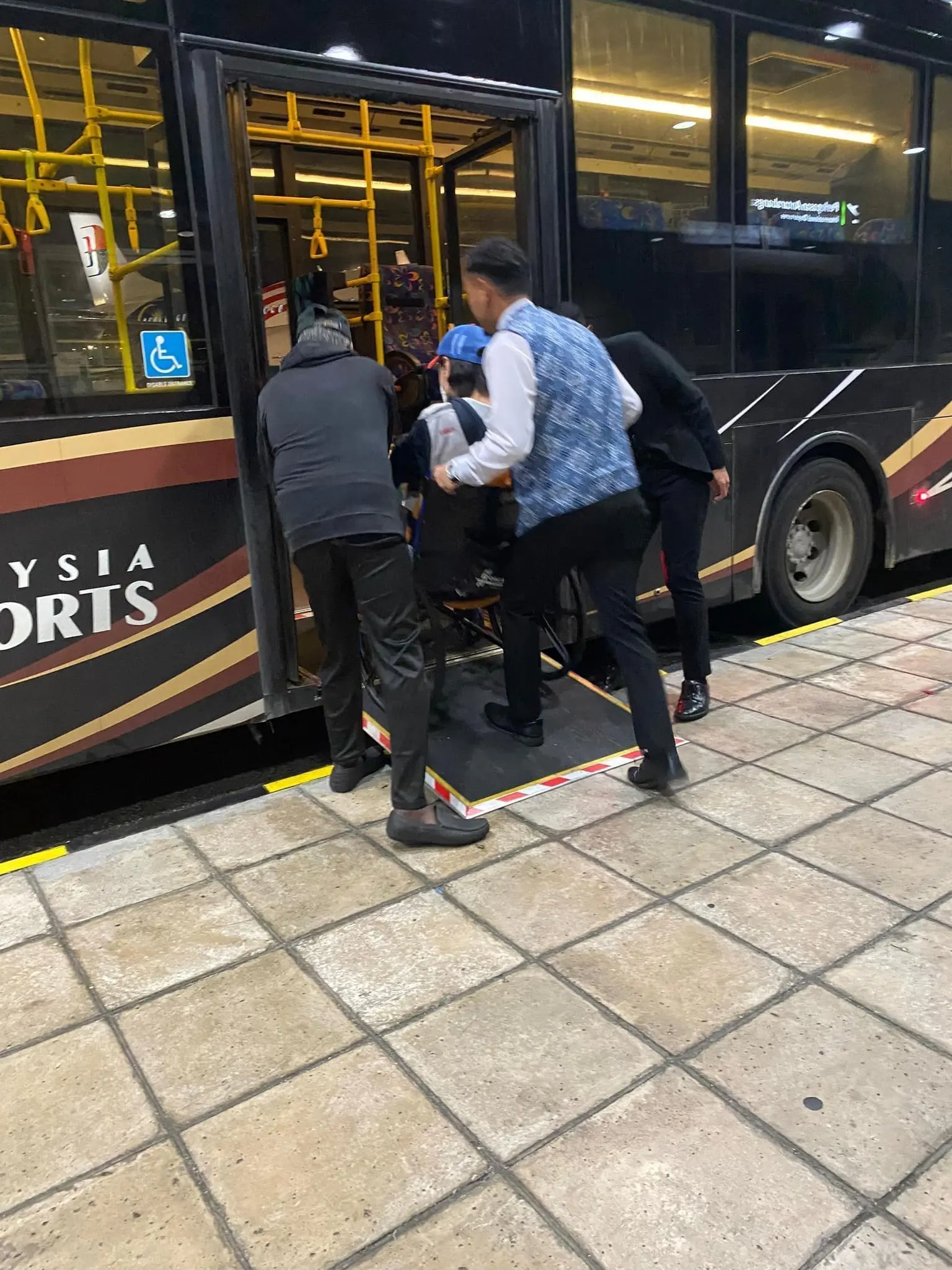 cabin crew helping passenger to get on the bus