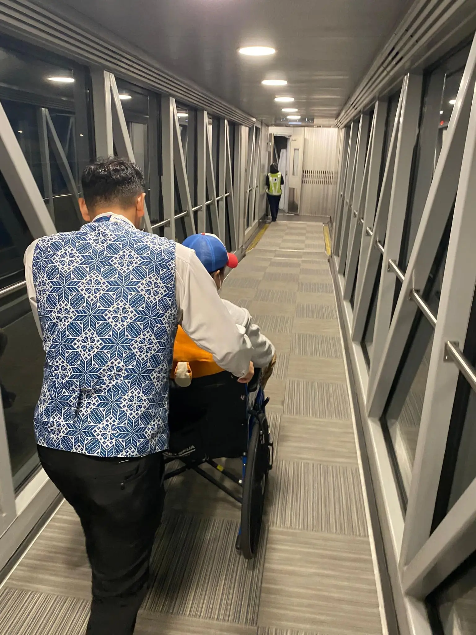 cabin crew pushing passenger in a wheel chair