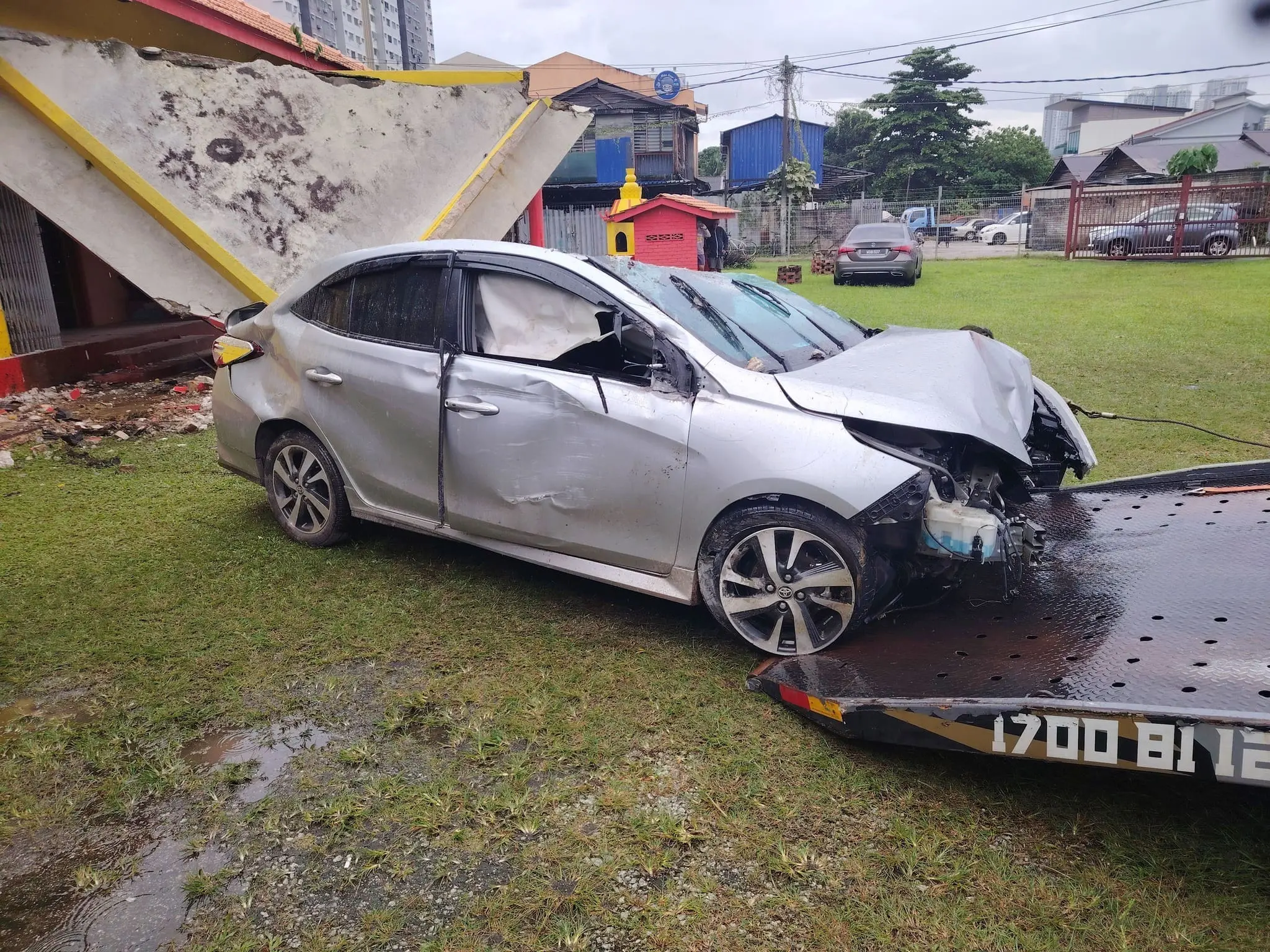 Car being towed away after crashing into temple pillar