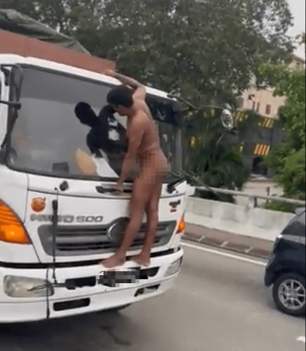 Naked man latching himself on a lorry