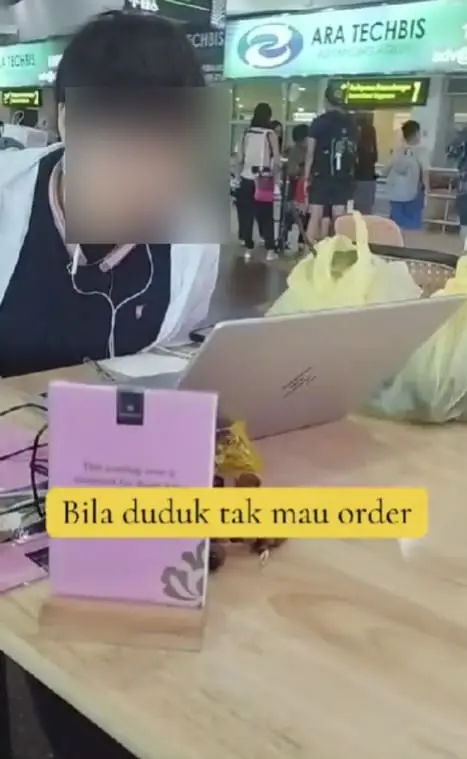 china tourist doing work at an eatery at penang international airport