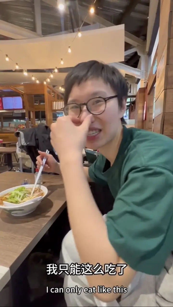 China woman pinches her nose before eating asam laksa