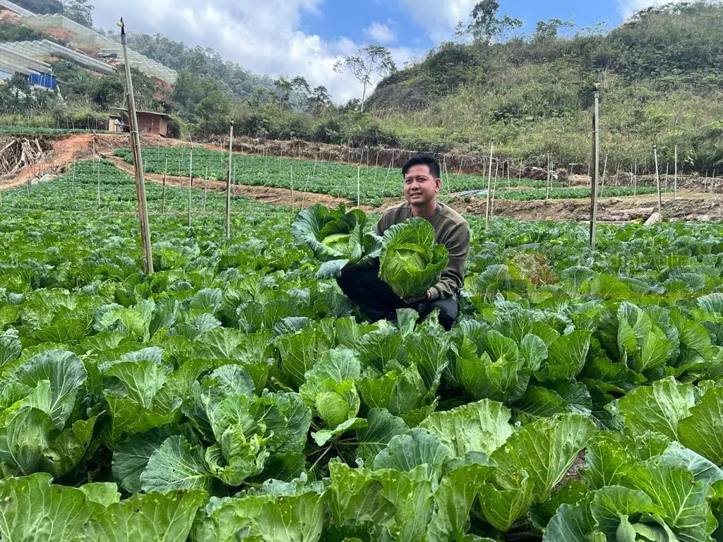 Chung Chia Khang sitting at his farm