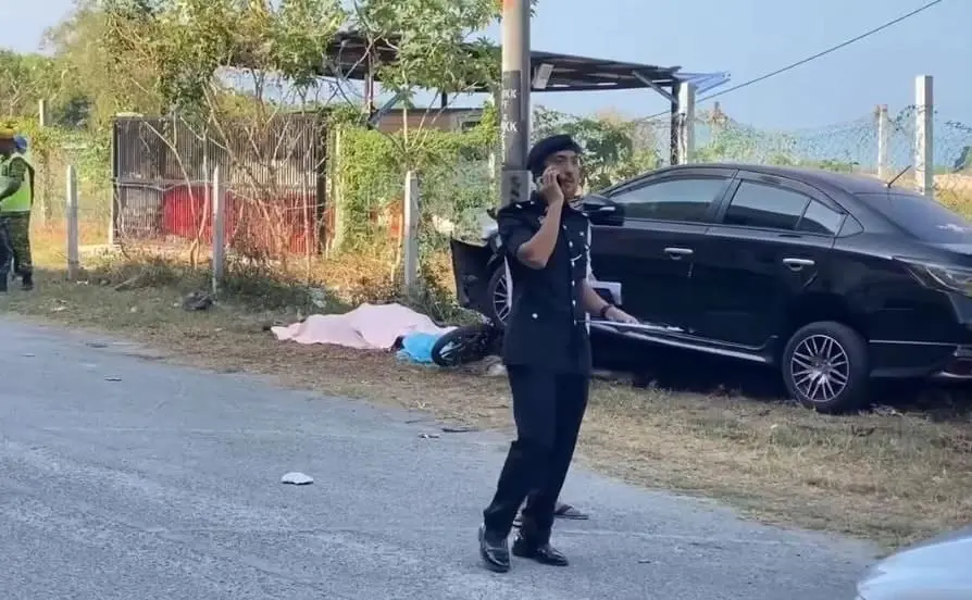 M'sian policeman walks by the body of dead thief in Kedah