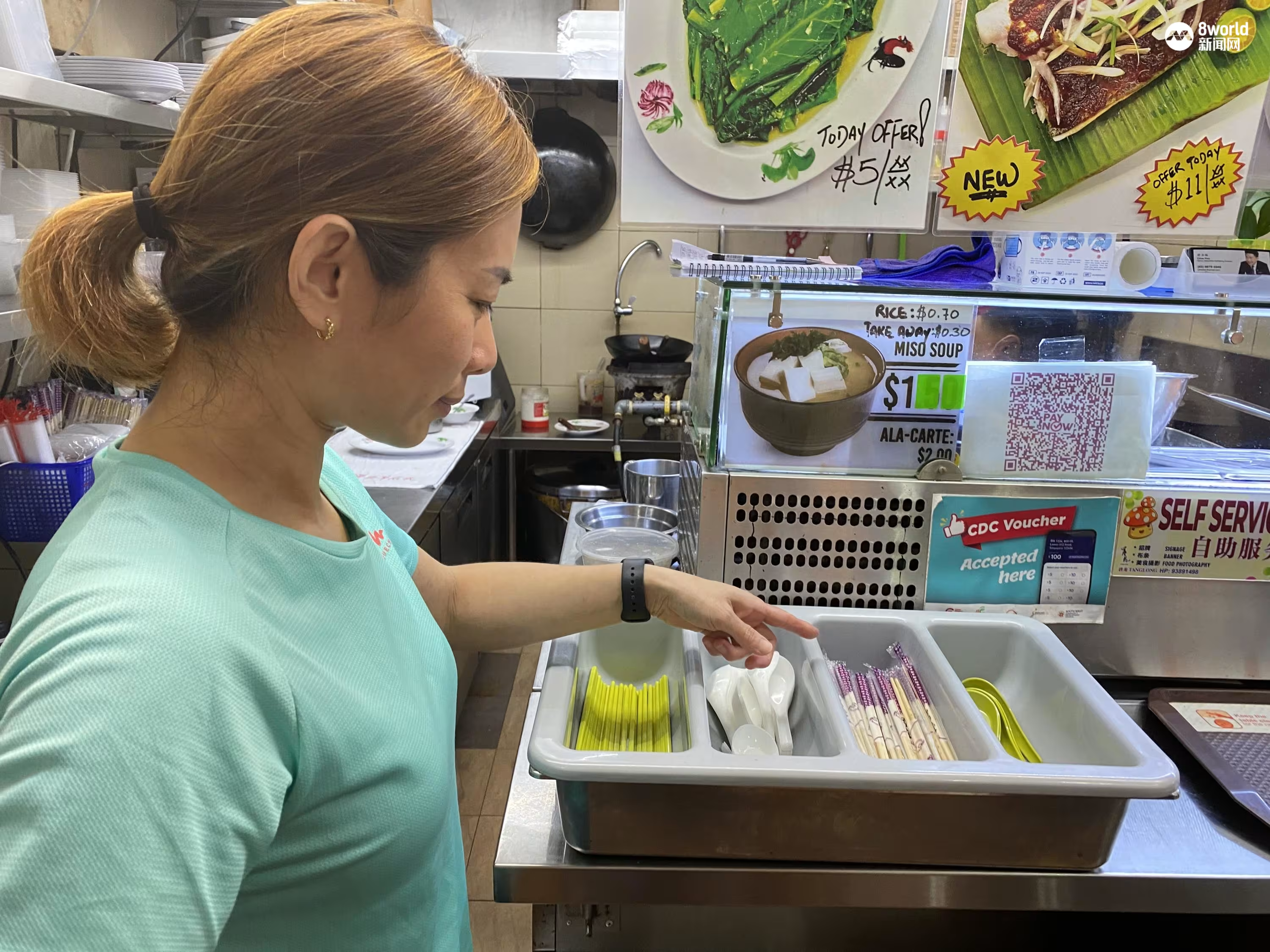 Woman points to disposable chopsticks at Maxwell Food Court, Singapore