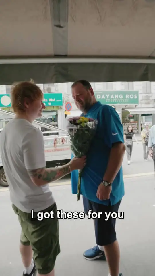 ed sheeran giving flowers to his guide