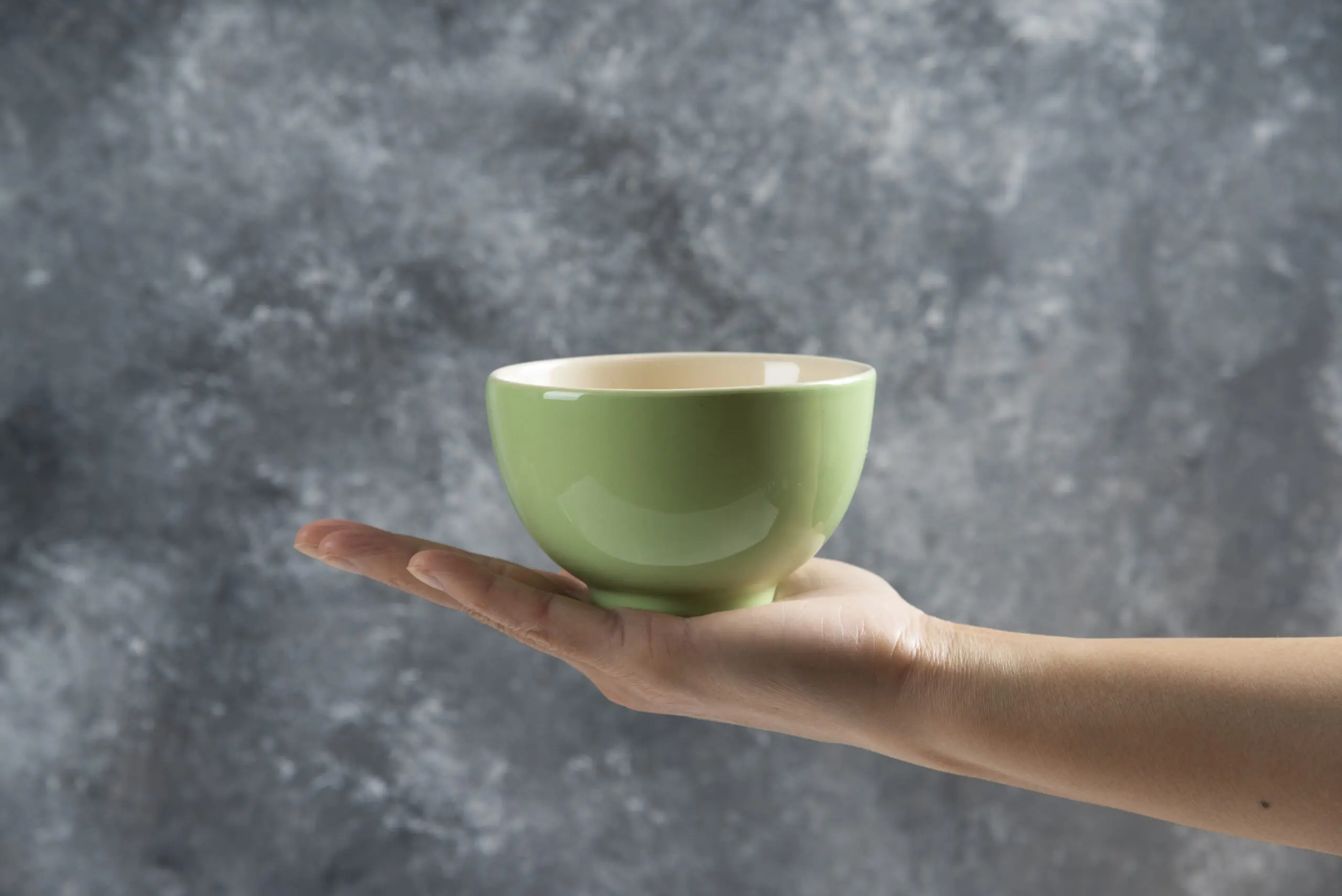 A person holding a green bowl