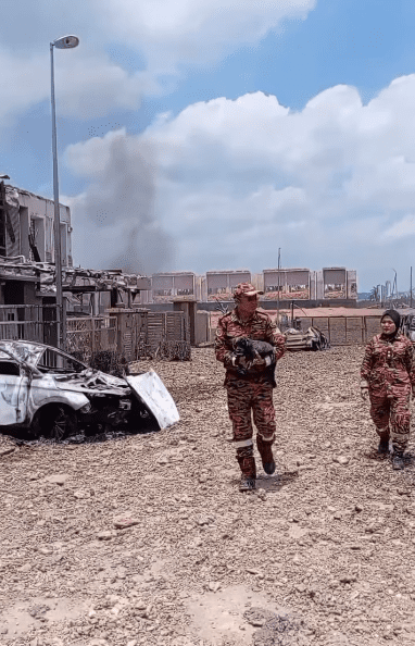 firefighter rescuing a black dog from the putra height pipeline explosion