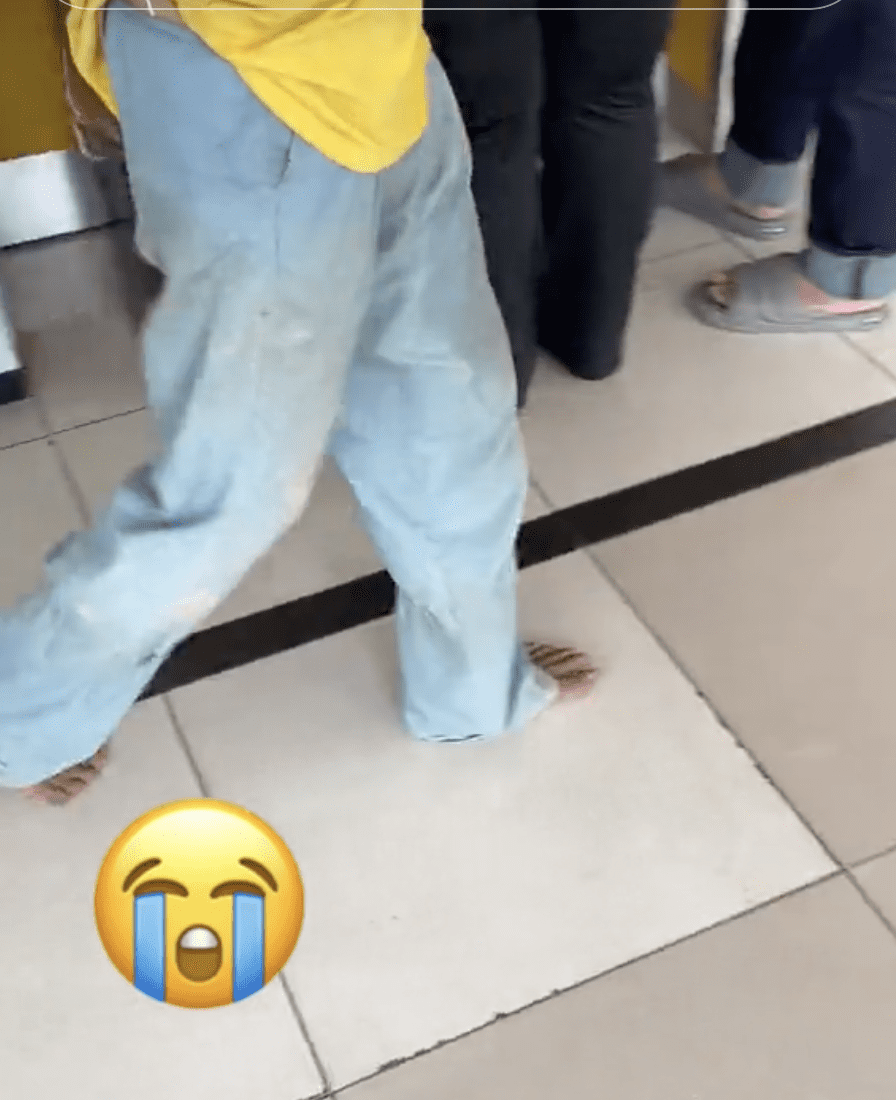 Foreign Worker removes shoes at ATM 02