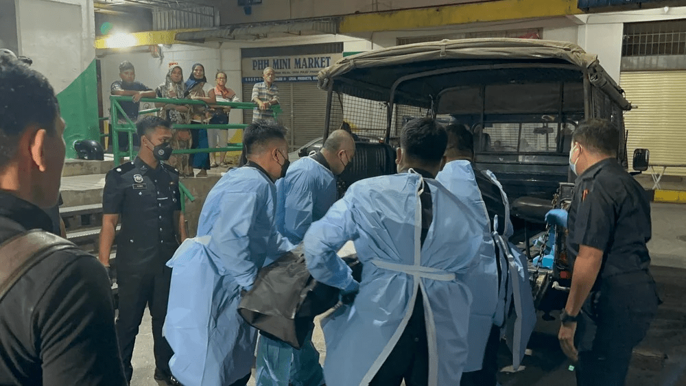 Forensic staff remove woman's body from Relau apartment