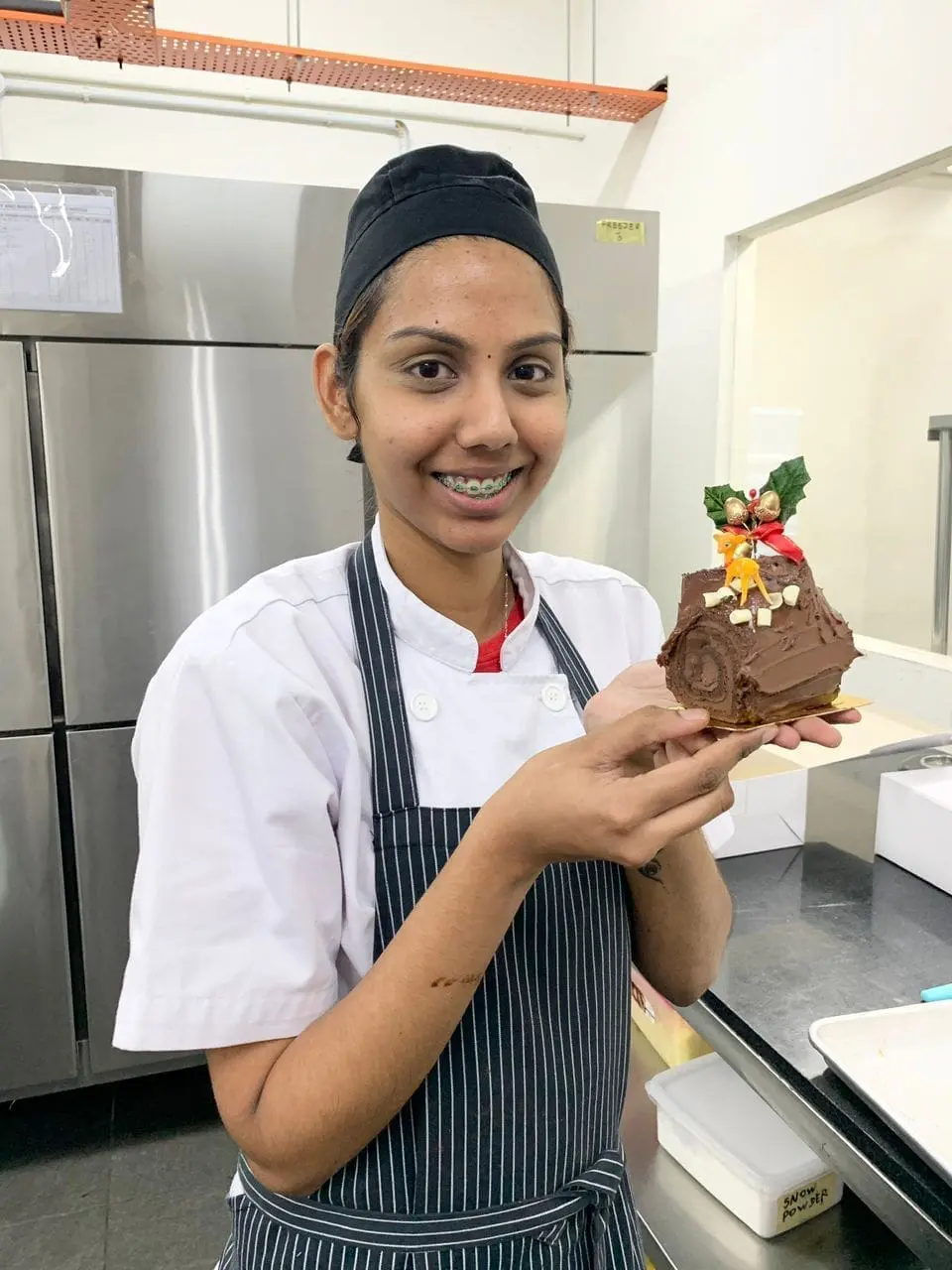 gilr showing a desert that she made at a culinary class