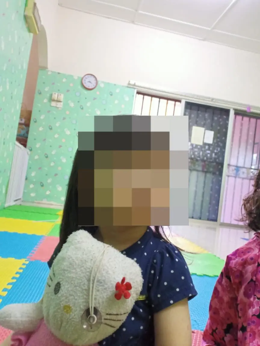 girl holding a hello kitty plushie