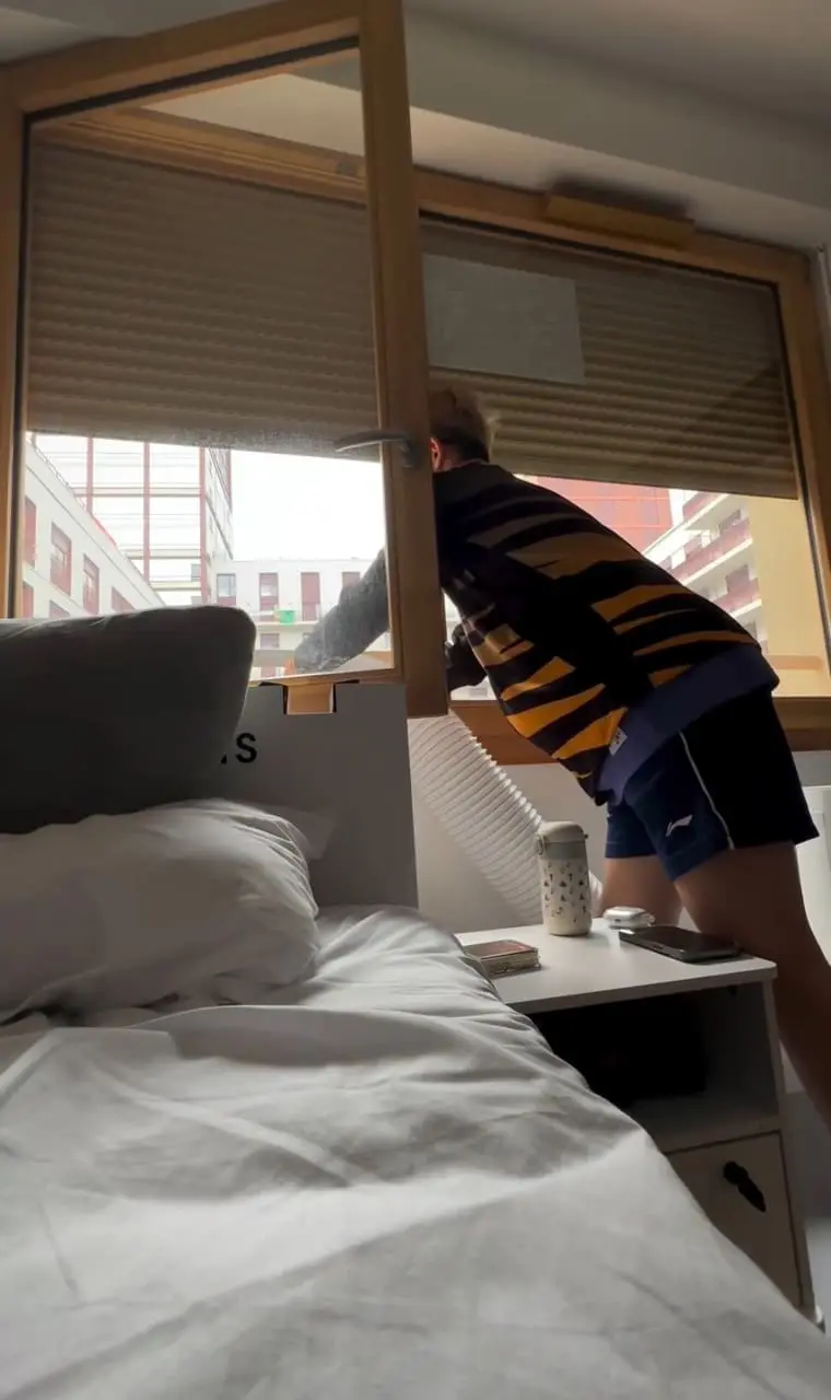 Goh Jin Wei fixing aircond hose at olympic village