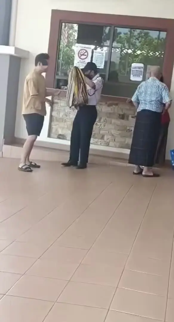 Guard giving M'sian man a sarong