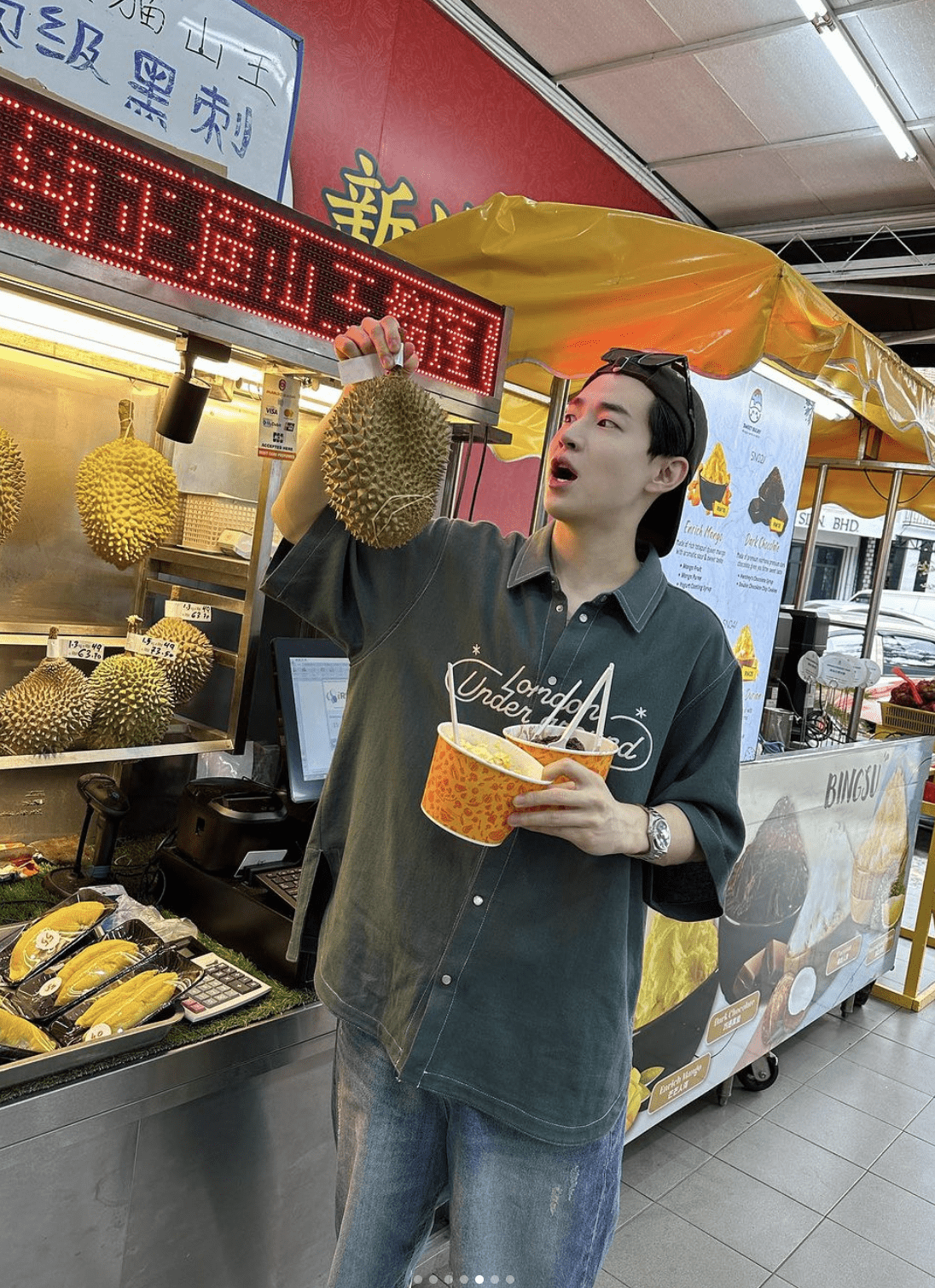 Henry Lau in petaling street posing with a musang king durian