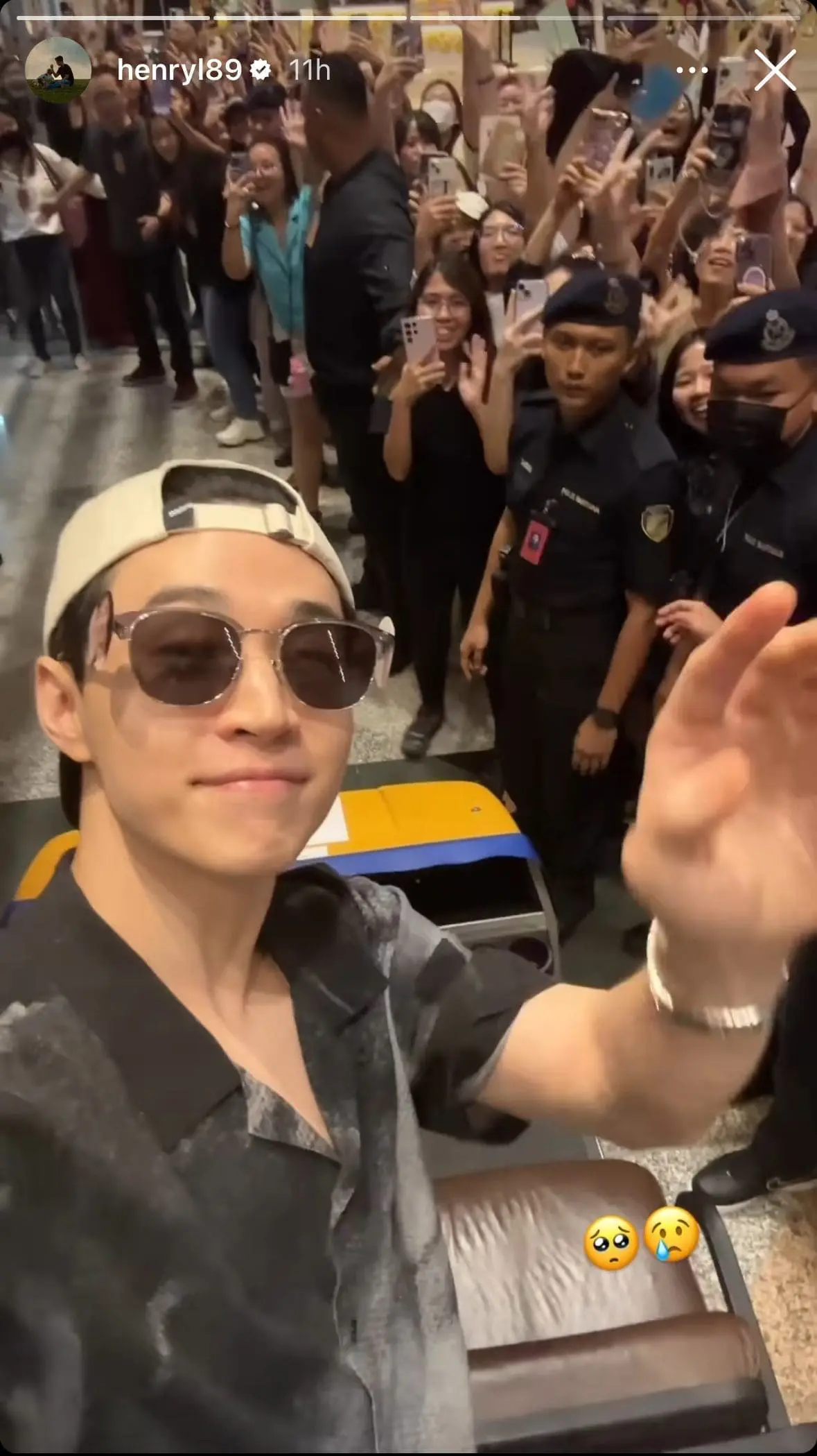 Henry Lau waves at his fans at KLIA